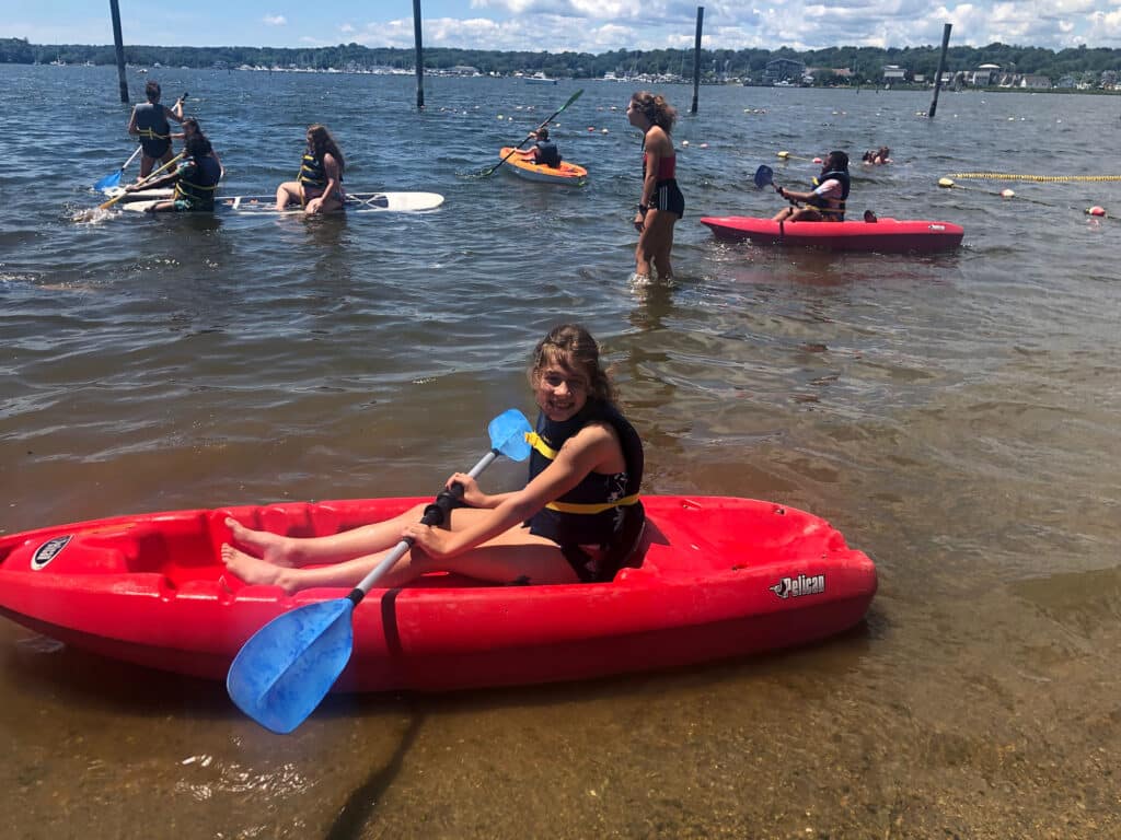 Child on beach on Kayak | YMCA Ocean Community | YMCA In Rhode Island